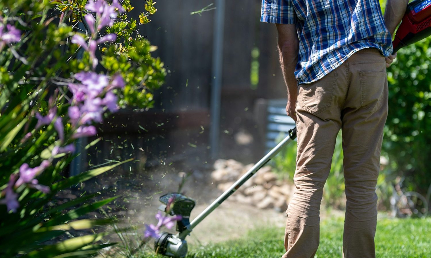 Person using a lawn mower to cut grass